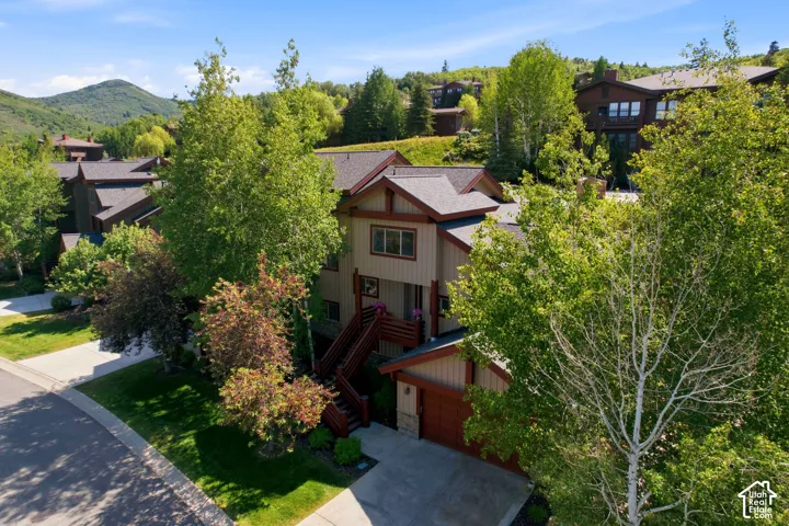Multi-level residence featuring a two-car garage, pitched roofline, and an exterior balcony