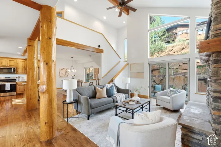 Great room featuring soaring ceilings, a stone-clad fireplace, and expansive windows