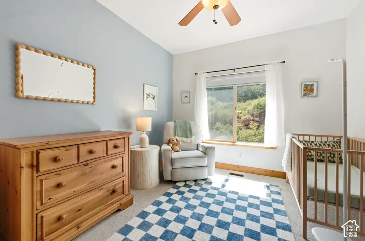 Room featuring a ceiling fan, a window with a wood sill, and light-colored carpeting