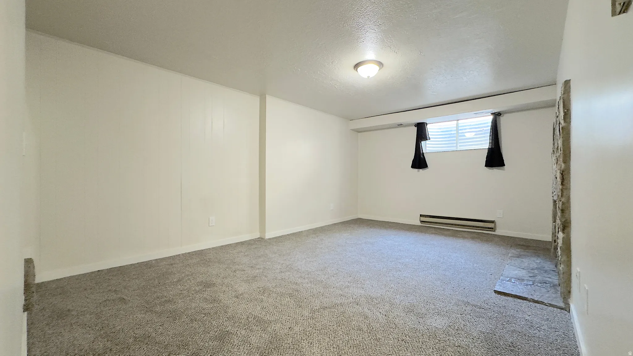 Spacious family room featuring a wood burning stone-clad fireplace and new carpet.