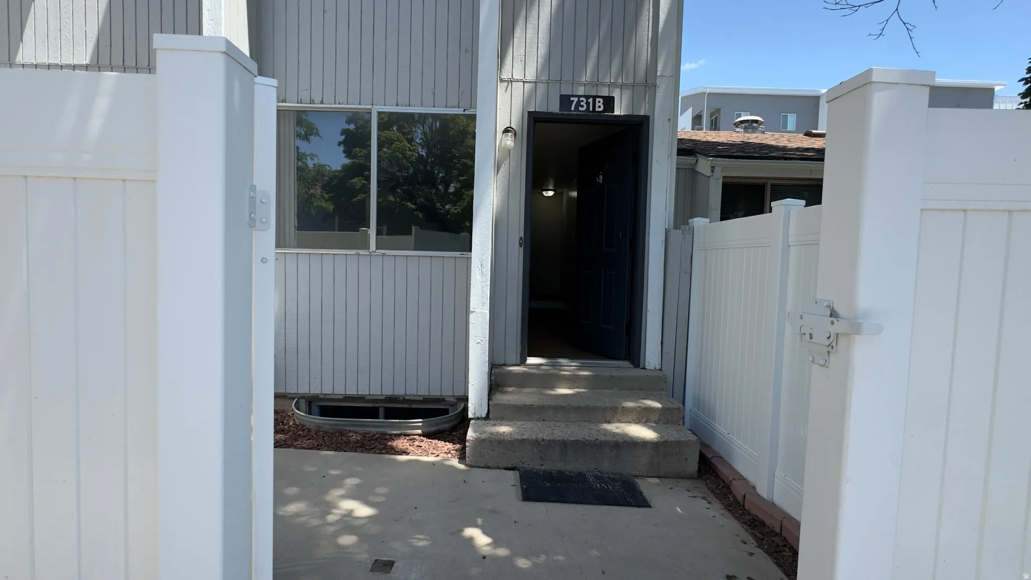 Front entry behind private fenced in patio.