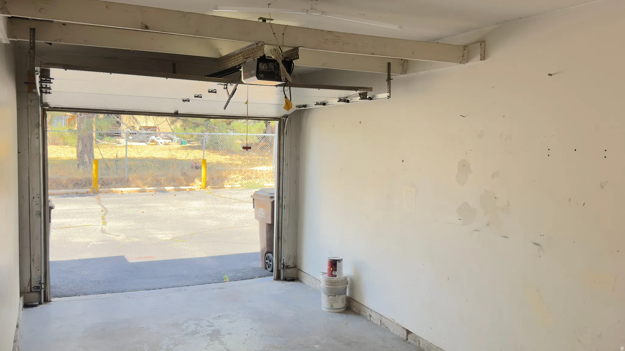 Garage featuring an automatic overhead door, concrete flooring.