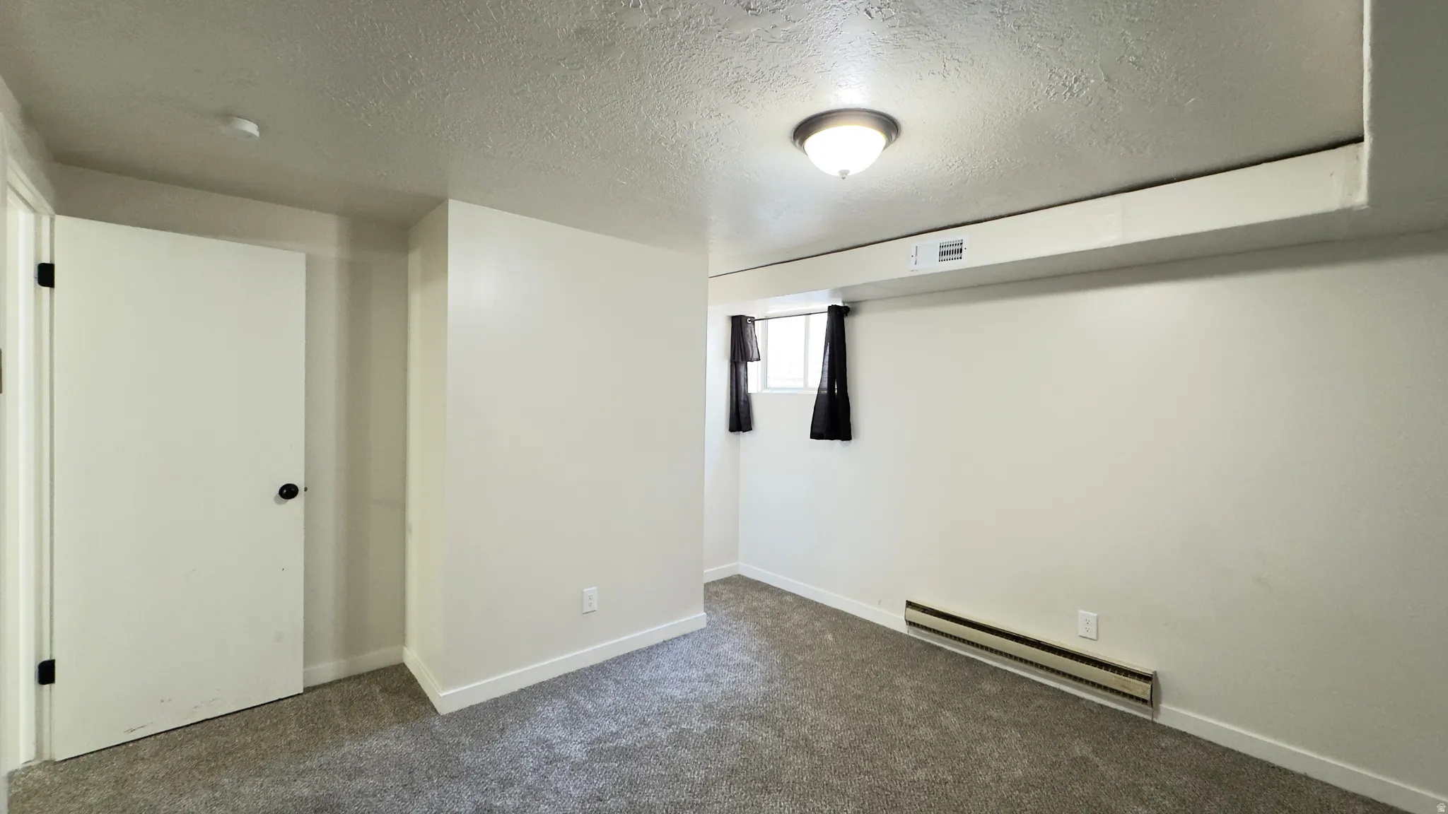 Basement, bedroom room featuring new carpet.