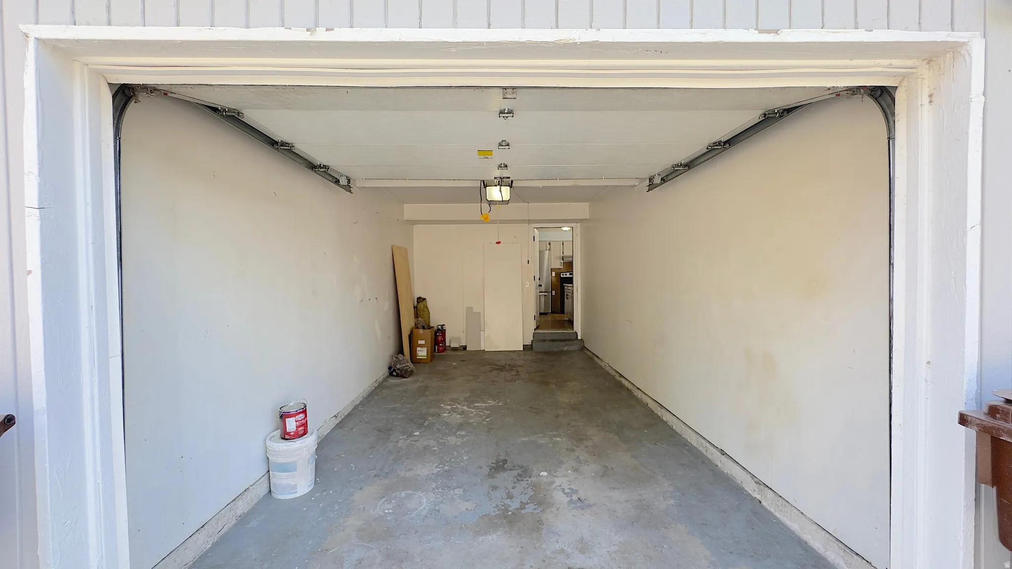 Spacious garage with concrete flooring, and overhead lighting.