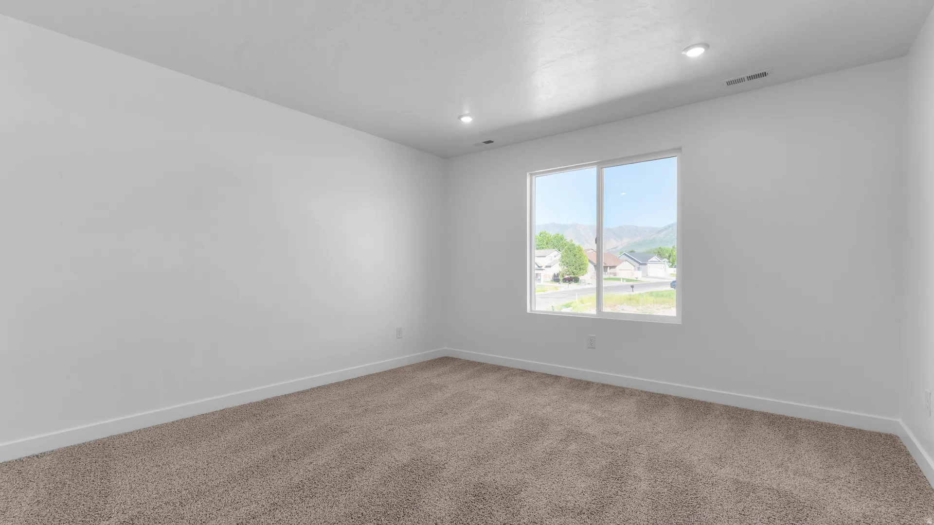 Window with mountain backdrop, recessed lighting, neutral carpeting, and white baseboards