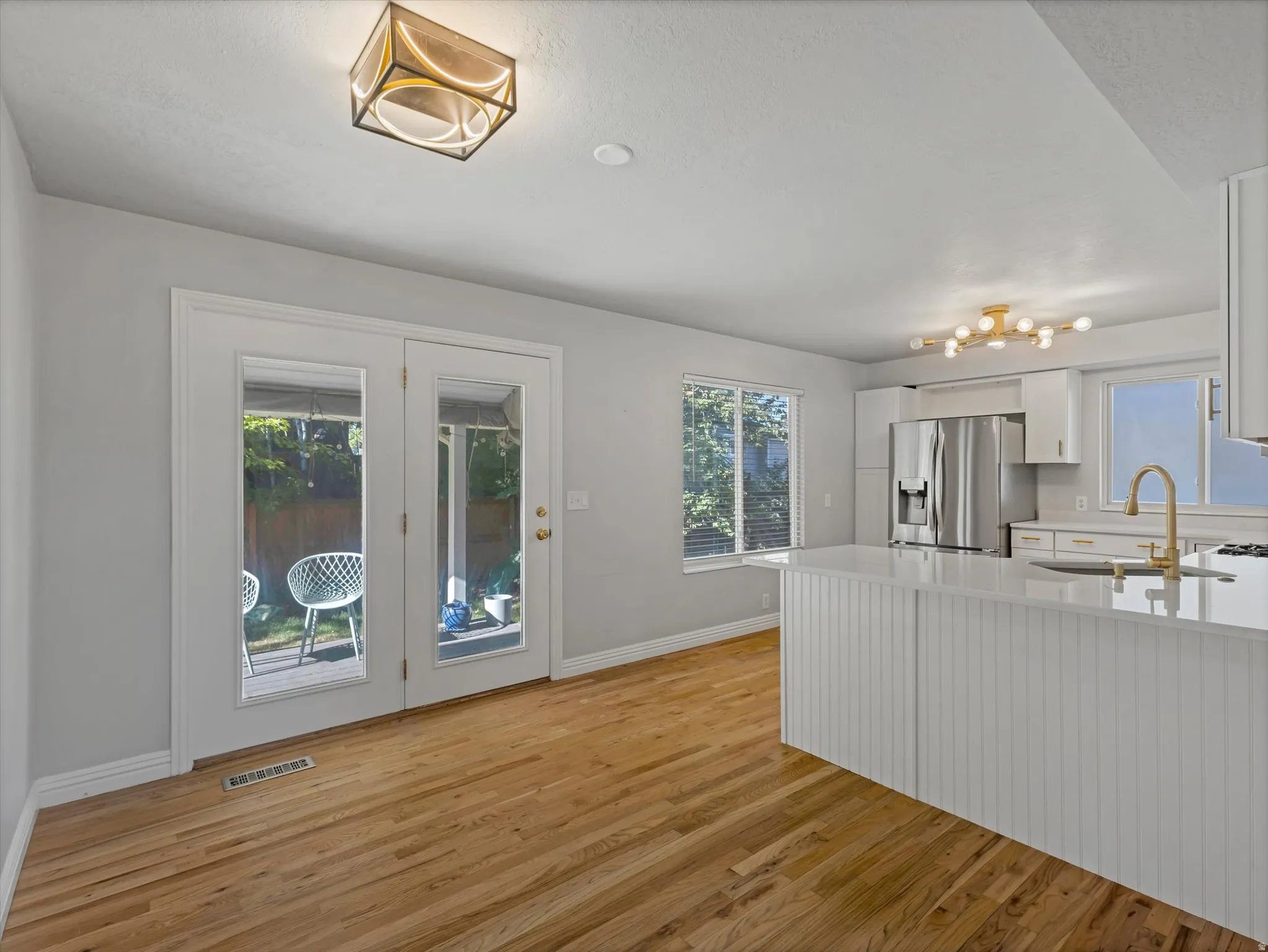 Open concept living space featuring wood-finish flooring and a contemporary overhead light fixture