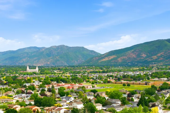 Expansive mountain backdrop framing a residential area with varied rooflines and mature trees