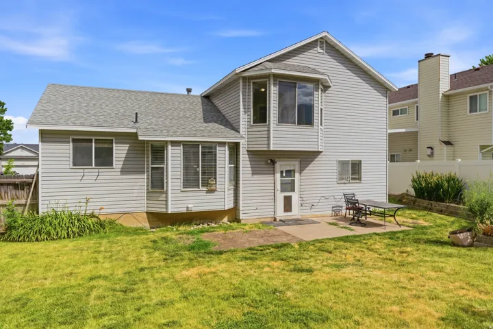 Rear exterior featuring light grey siding and a shingled roof