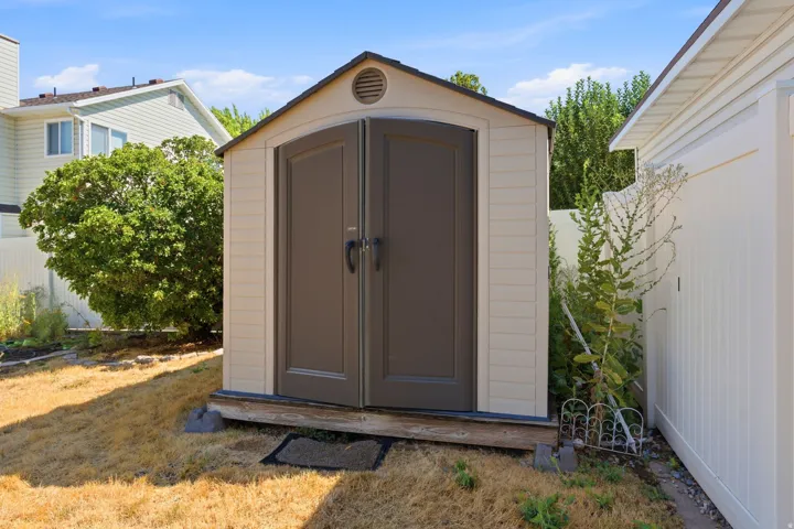 Freestanding storage shed with double doors and an arched top