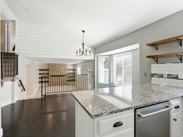 Open-concept living space featuring wood flooring, white shiplap accent wall looking into main level family room