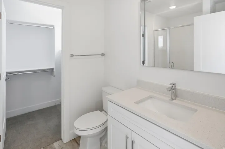 Bathroom vanity featuring a quartz countertop and integrated sink with a chrome faucet