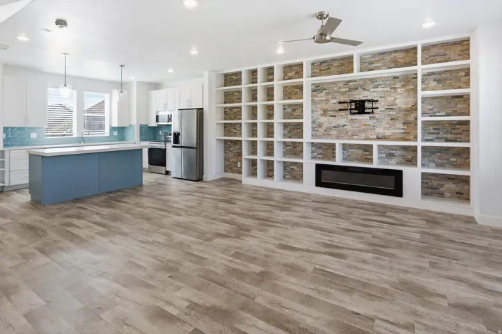 Open-concept living area featuring wood-finish flooring, a contemporary ceiling fan, and recessed lighting