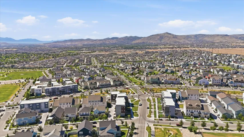 Expansive neighborhood featuring various architectural styles, open green spaces, and paved streets