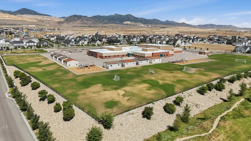 Expansive property featuring a large school building, multiple athletic fields, and a dedicated playground area