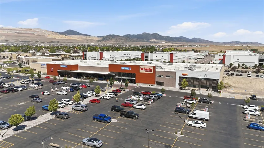Expansive commercial property featuring multiple retail storefronts and a large, paved parking lot