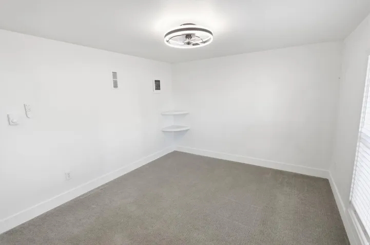 White-painted room with gray carpet flooring and white trim