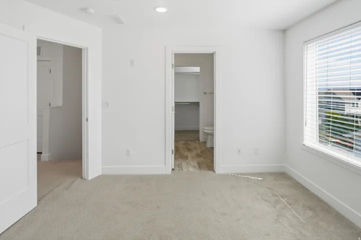 Carpeted interior space featuring recessed lighting and a window with horizontal blinds