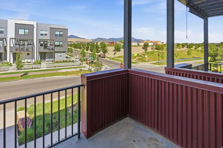 Balcony featuring concrete flooring, a black metal railing, and corrugated metal siding