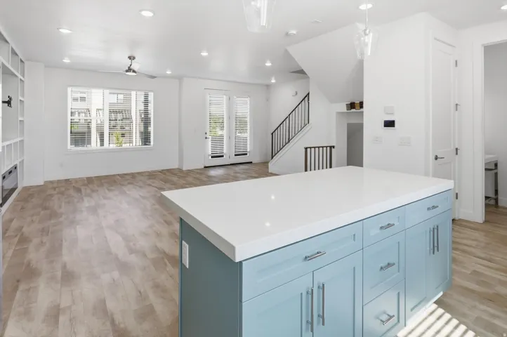Kitchen island featuring light blue cabinetry, chrome hardware, and a white countertop
