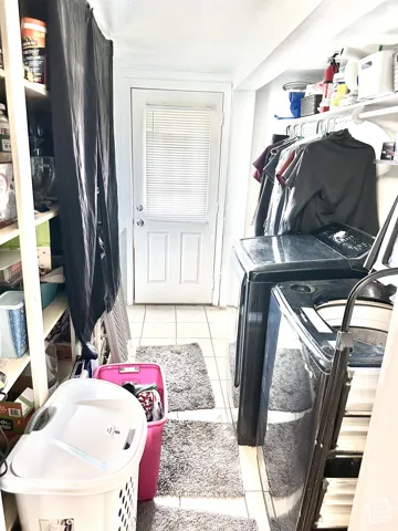 Utility area featuring tile flooring, built-in shelving, and exterior access door with an integrated window