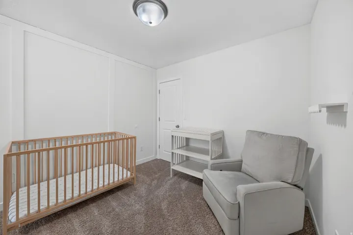 Interior room featuring white walls, textured carpeting, and a flush-mount ceiling light fixture