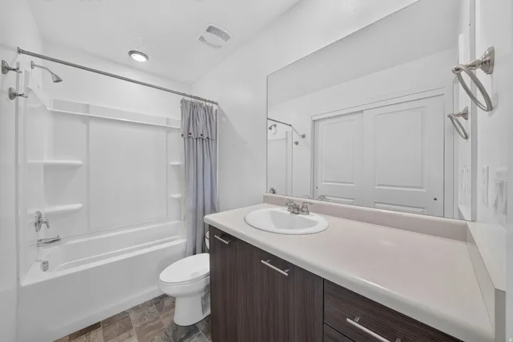 Bathroom vanity featuring a white oval sink, chrome faucet, and a light-toned countertop