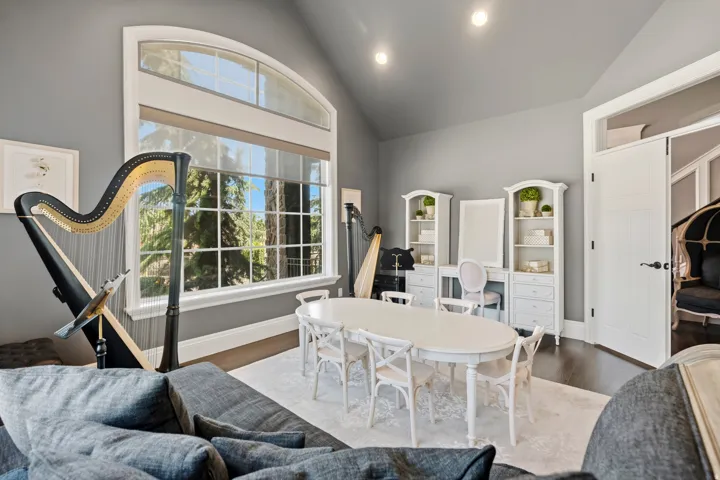 Spacious room featuring a vaulted ceiling and a large arched window