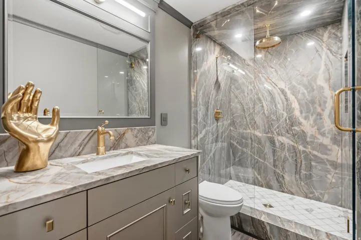 Bathroom featuring a walk-in shower with a glass enclosure, a built-in shower bench, and a rain showerhead