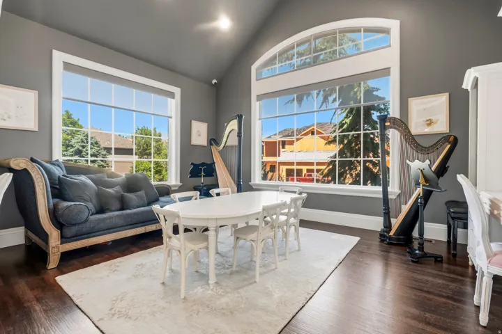Vaulted ceiling room featuring dark wood-finish flooring