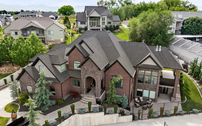 Brick and stone exterior featuring multiple gables and a dark shingle roof