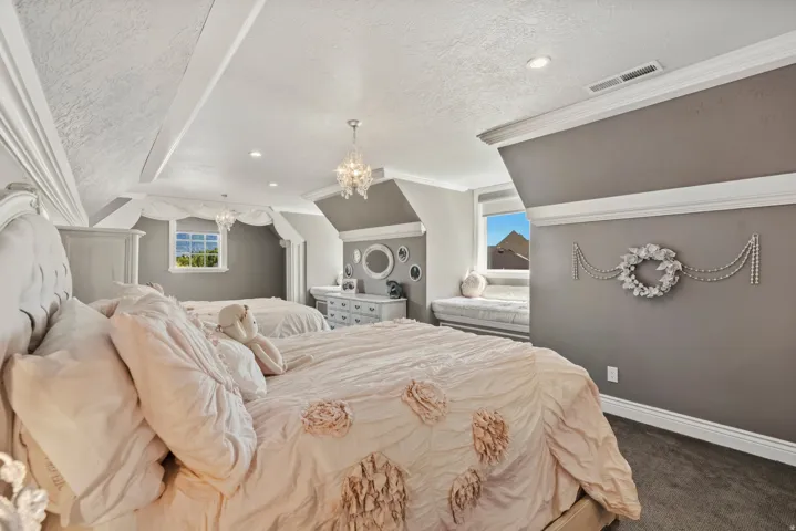 Spacious room featuring sloped ceilings, recessed lighting, and crown molding