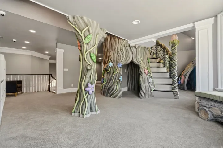 Custom-built play structure featuring a tree-trunk motif, integrated staircase, and whimsical floral accents