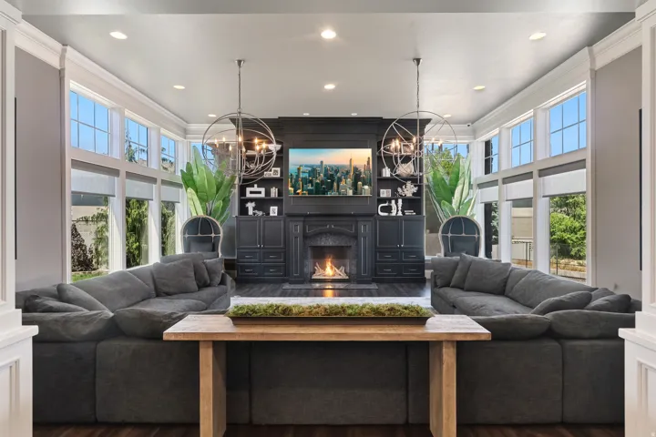 Spacious living area featuring dark wood-finish flooring, a central fireplace with a dark mantel, and built-in shelving