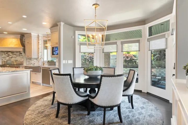 Bright dining area featuring a bay window with multiple glass panel doors providing exterior access