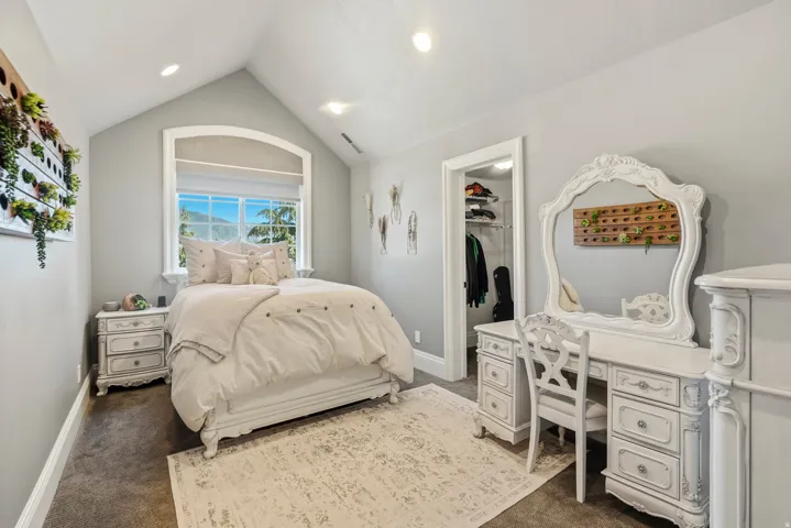 Vaulted ceiling room featuring carpet flooring, recessed lighting, and a window with mountain scenery