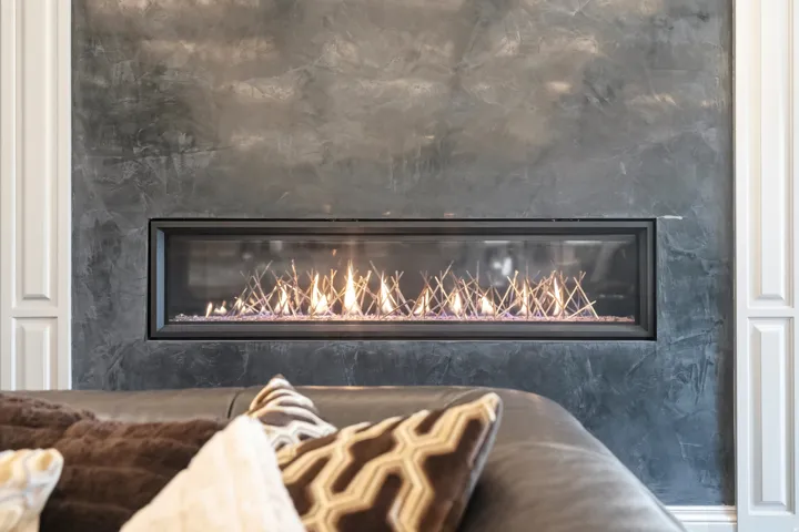 Modern linear fireplace featuring a textured dark surround and contrasting white paneling
