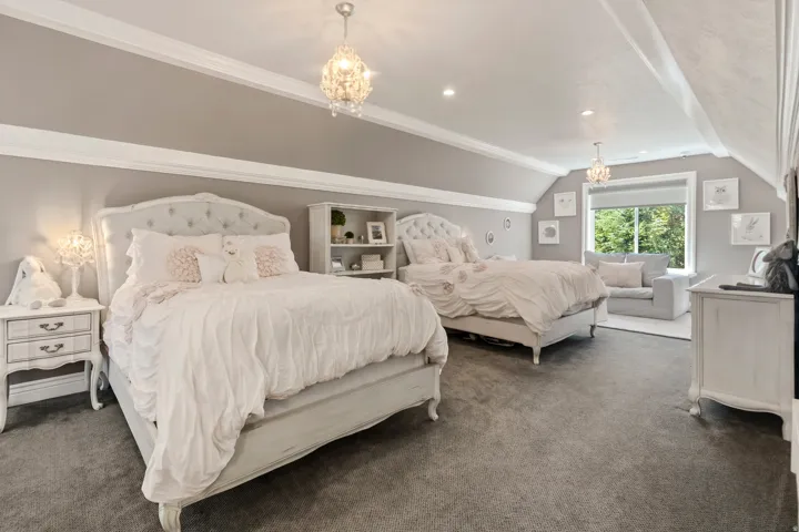 Spacious interior room featuring sloped ceilings, recessed lighting, and a large window providing natural illumination