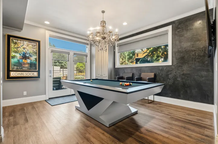 Wood-finish flooring throughout, featuring a modern chandelier and recessed lighting