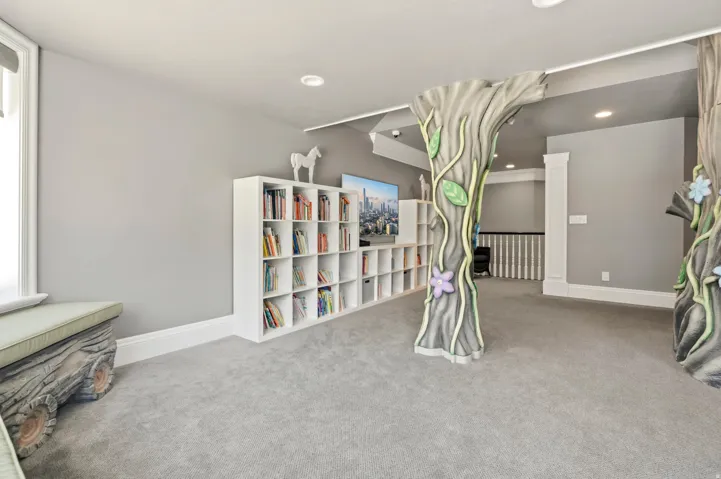 Recreation room featuring custom tree-like architectural elements, light gray carpeting, and recessed lighting