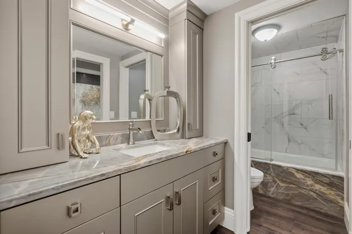 Bathroom vanity featuring a single undermount sink and a polished stone countertop