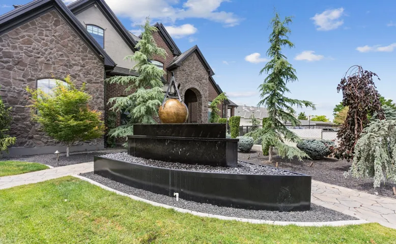 Stone and brick facade residence featuring a multi-tiered water feature with an ornamental urn