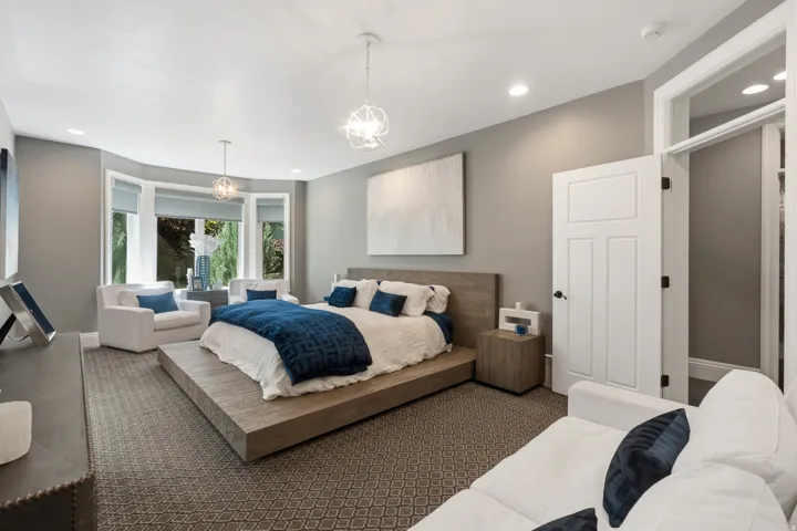 Spacious room featuring a bay window, recessed lighting, and patterned carpeting