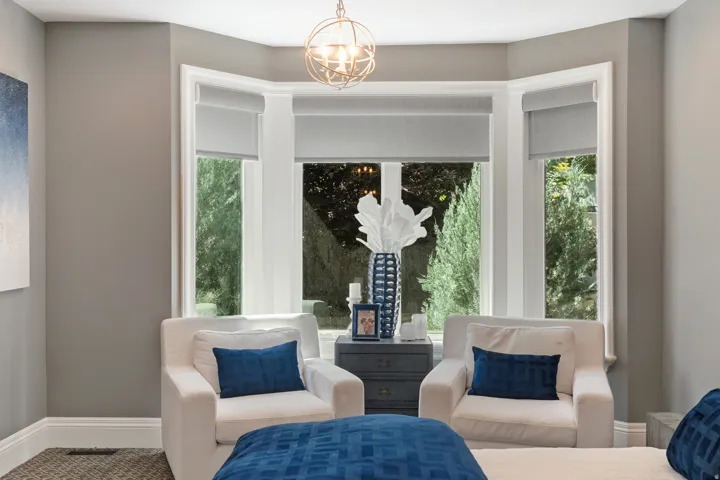 Bay window with white trim and roller shades