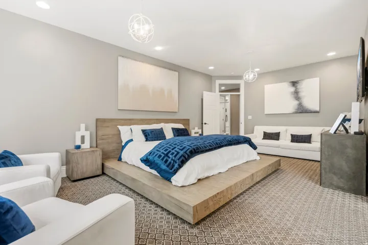 Spacious sleeping area featuring recessed lighting and two contemporary spherical light fixtures