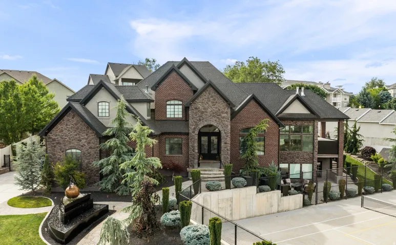 Stately brick and stone exterior residence featuring multiple gables and dormers
