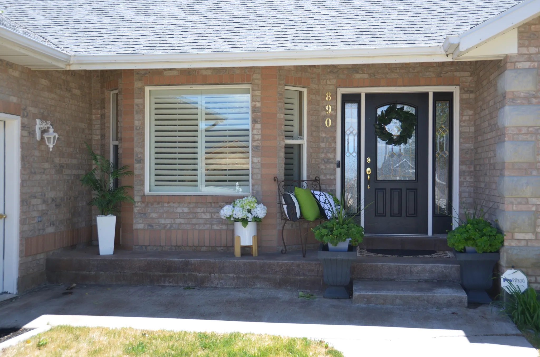 Brick exterior with a dark entry door featuring decorative glass side panels and a transom window