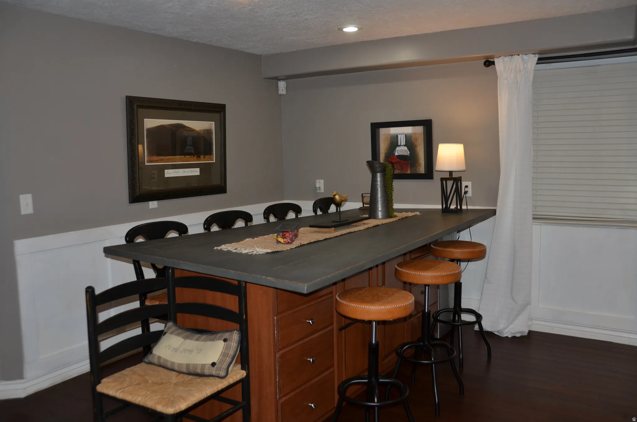 Expansive island featuring a dark countertop and wood-finish cabinetry with multiple drawers