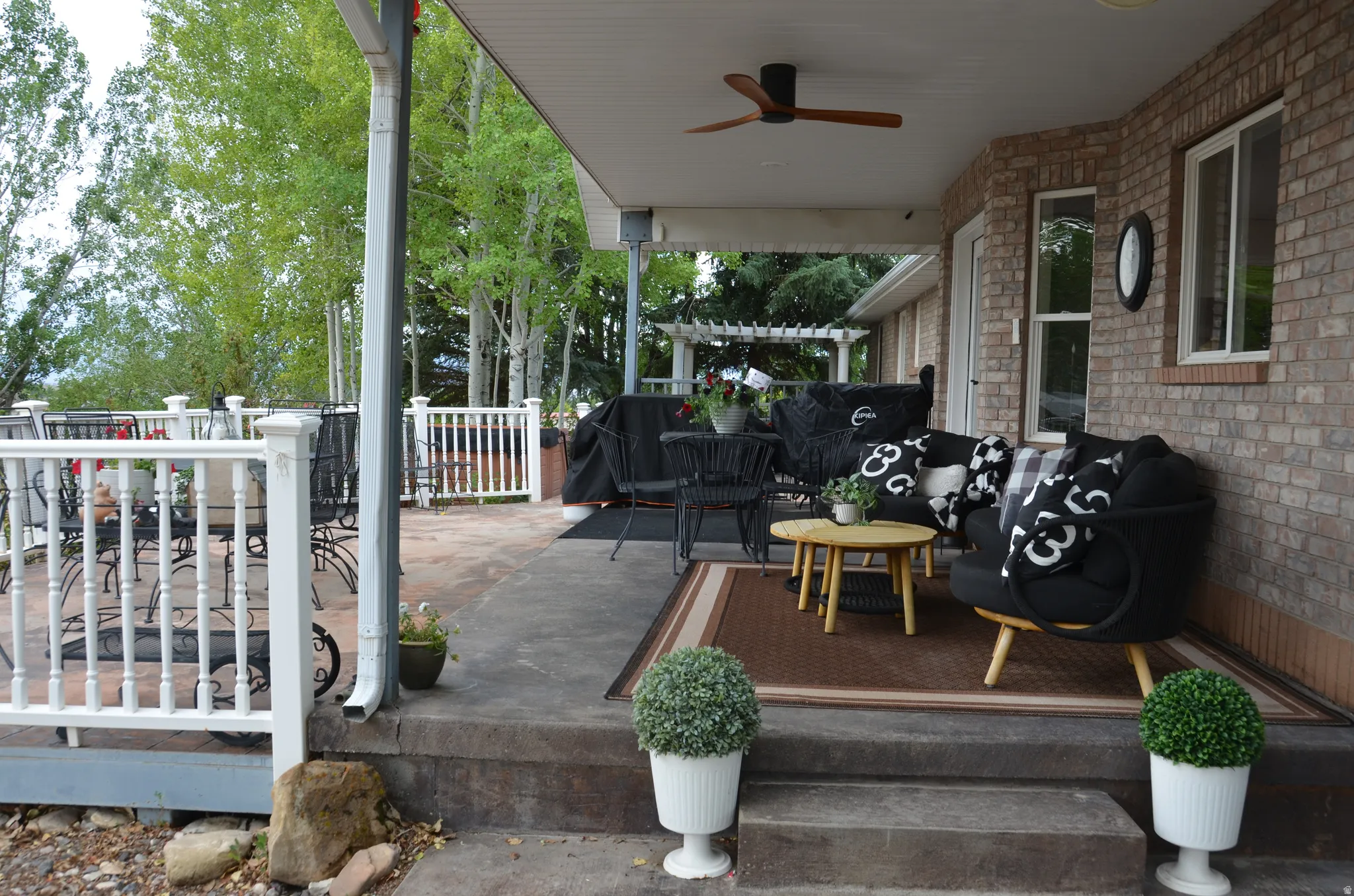 Brick exterior with a covered patio area featuring a ceiling fan