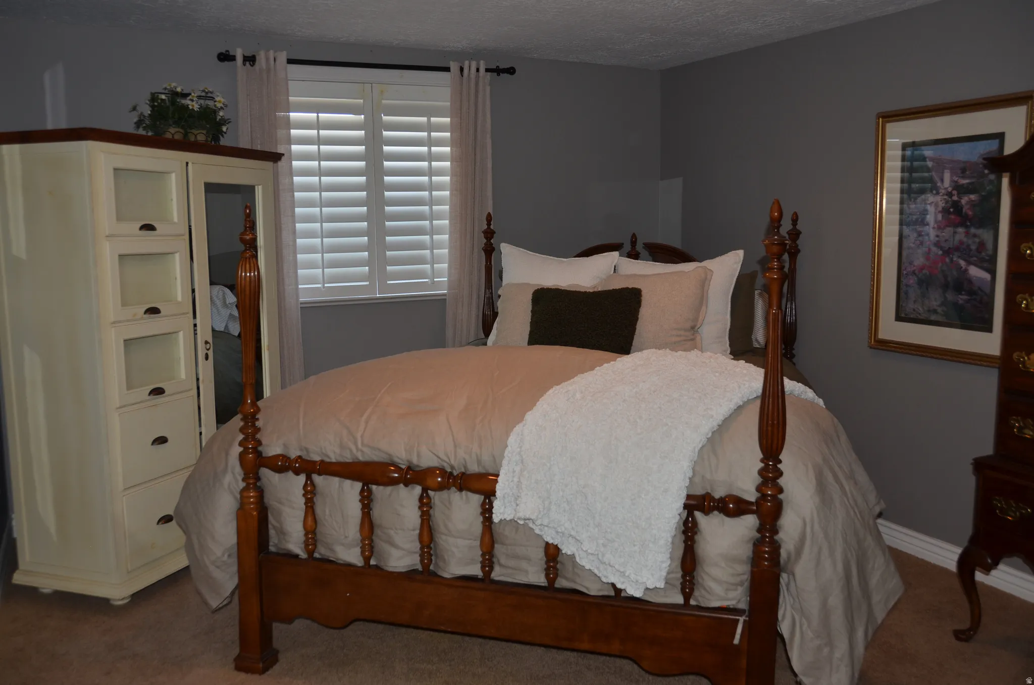 Bedroom with neutral gray walls and light-colored carpeting