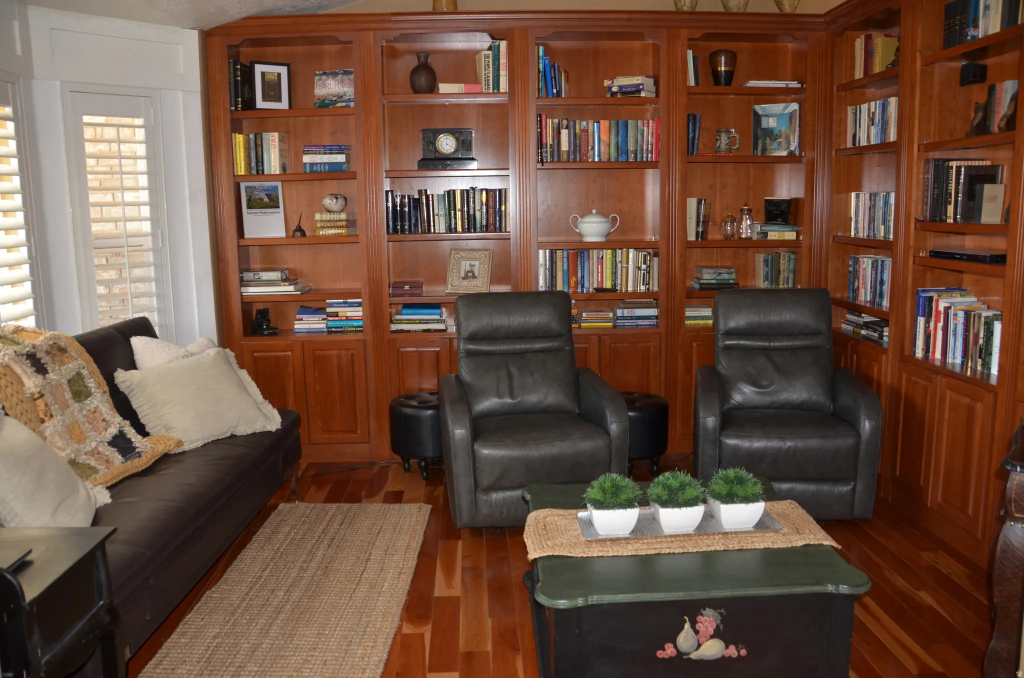 Warm study featuring extensive built-in cherry wood cabinetry with open shelving and lower storage